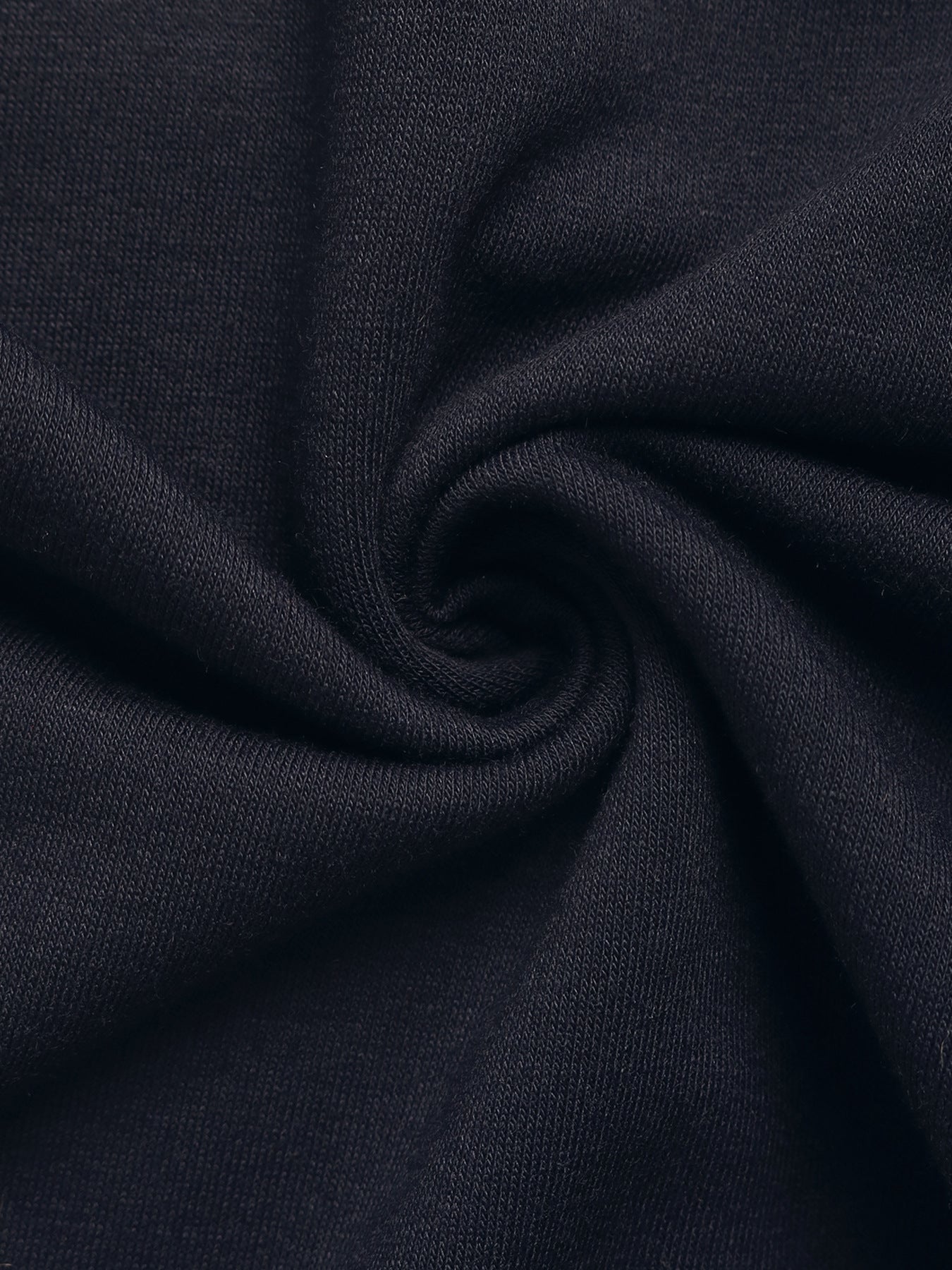 Close-up of soft navy fabric, twisted to display texture and stretchability.