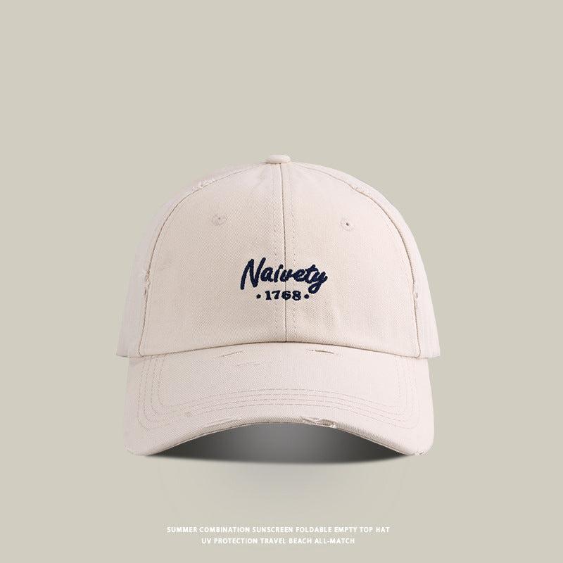 White baseball cap with navy 'Naivety 1768' embroidered logo