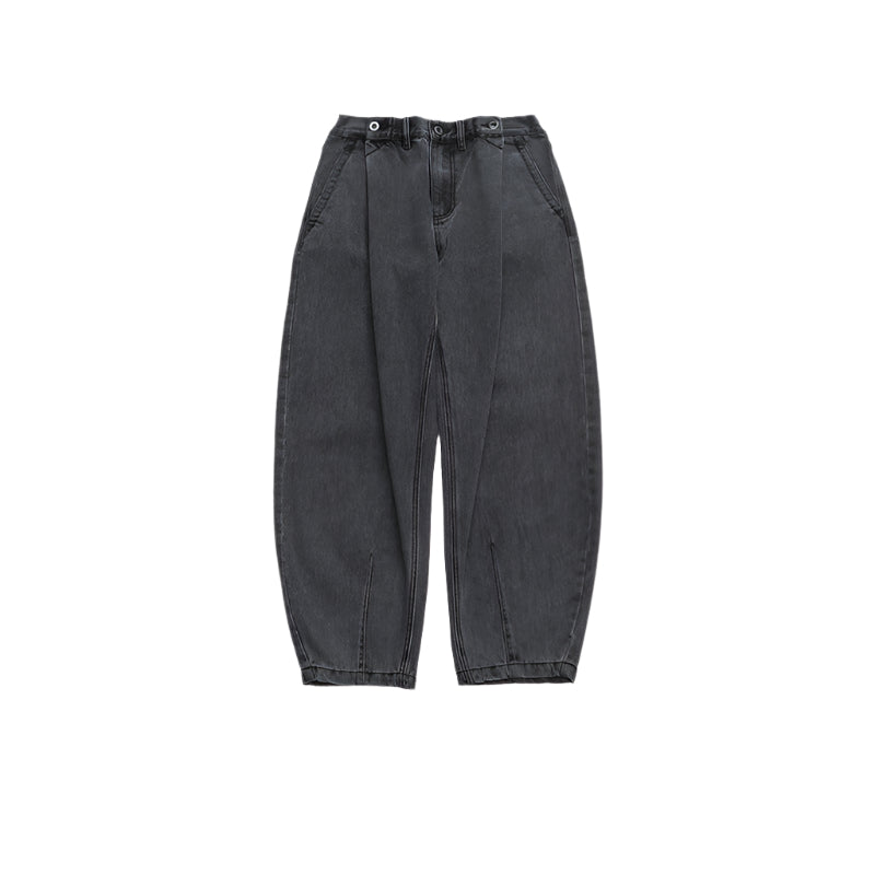 Front view of balloon-fit black denim jeans with three-button closure, pleated front and tapered ankles on white background