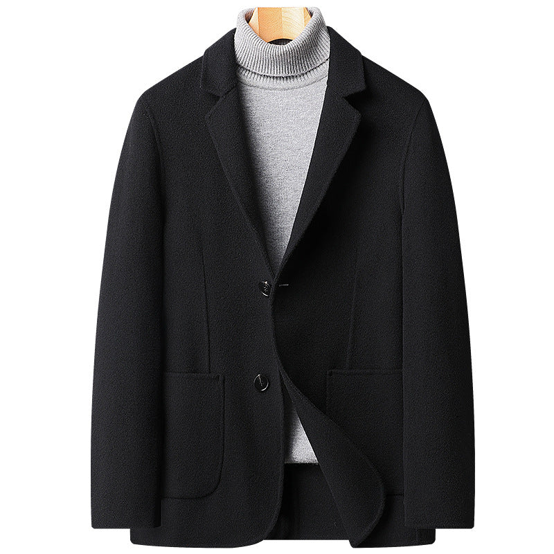 Black wool blazer with notched lapels and two-button closure, styled with a light gray turtleneck sweater on wooden hanger