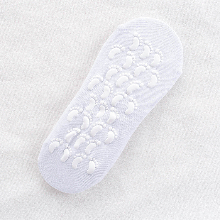 White non-slip ankle sock with white footprint grip pattern on sole displayed flat against white fabric background