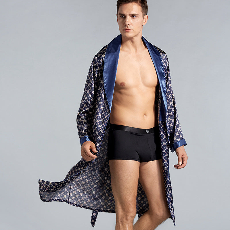 Man in open navy patterned robe wearing black boxer briefs. Close-up shows flowing silhouette and branded waistband against light gray studio background