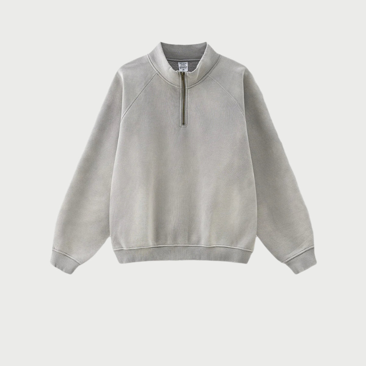 Light gray half-zip pullover with standing collar, brass zipper, ribbed cuffs, heavyweight cotton, minimalist style