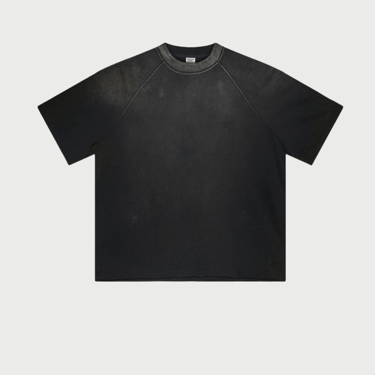Black oversized t-shirt with raglan sleeves and subtle wash effect displayed flat against light gray background