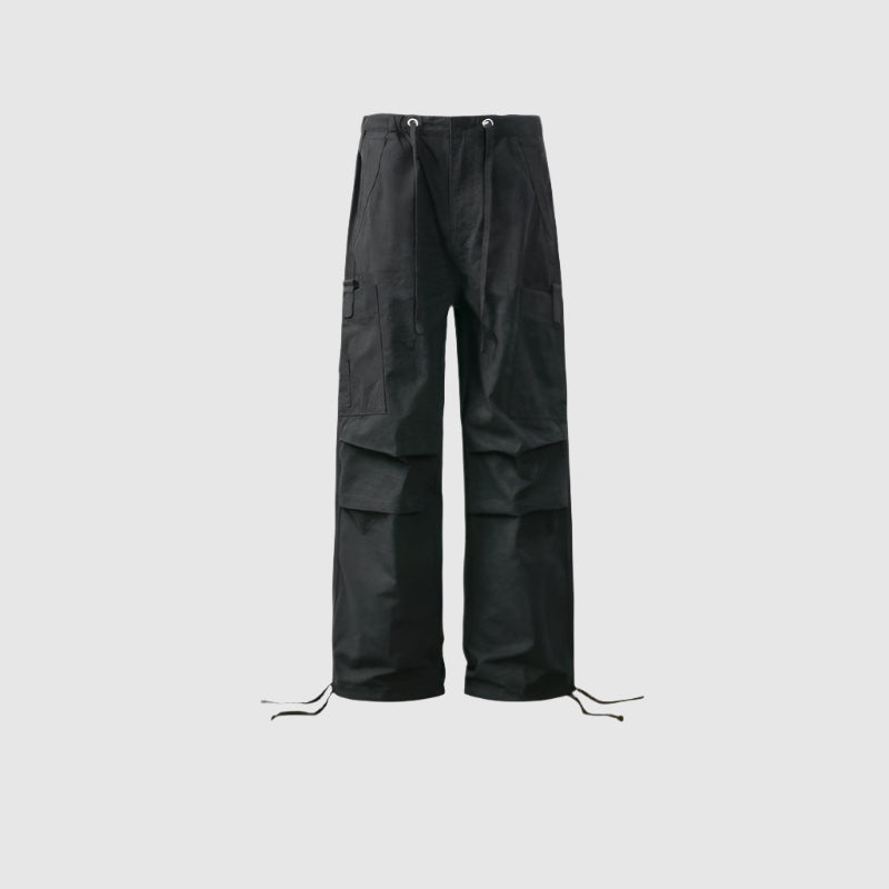 Black wide-leg cargo pants with drawstring hem, utility pockets and panel design displayed against light gray background