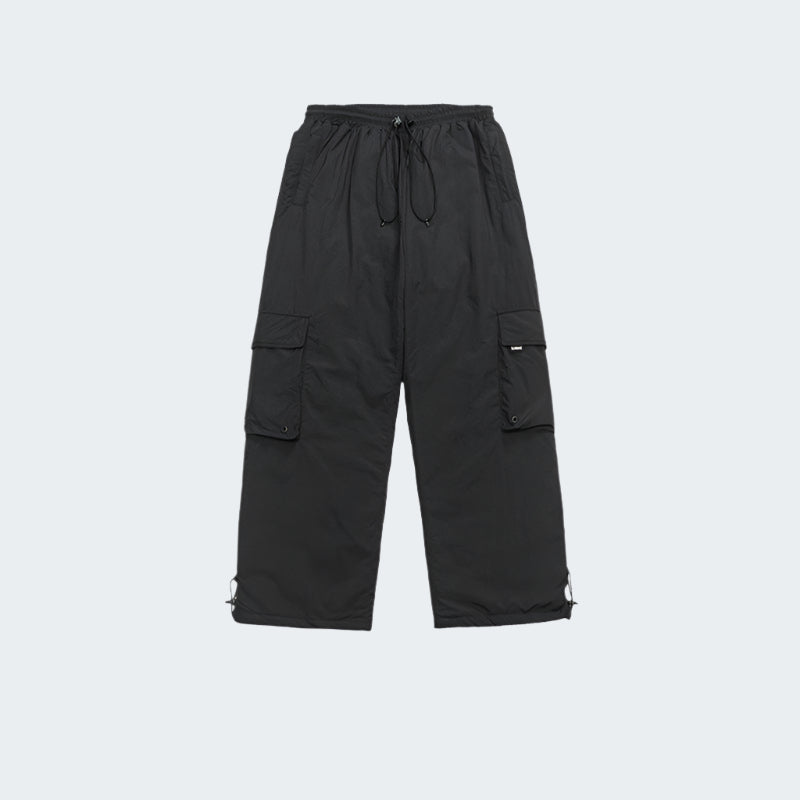 Flat lay product shot of black cargo pants with utility pockets and adjustable ankle cords