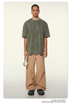Model in olive green oversized t-shirt paired with beige cargo pants and textured footwear, wearing silver chain necklace