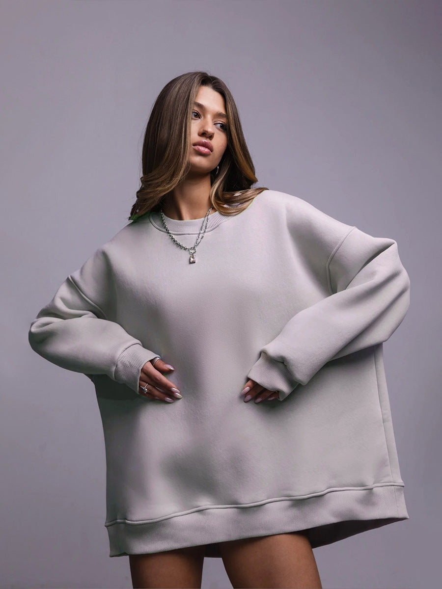 Grey oversized sweatshirt dress – Model wears a relaxed-fit grey sweatshirt dress with silver jewelry for a modern streetwear look