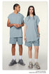 Male and female models wearing matching powder blue oversized tee and shorts sets with white socks and sneakers
