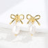 Gold bow stud earrings with pearl drop 925 silver flat lay