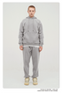 Male model with short ginger hair wearing a light gray sweatsuit set with hoodie and matching pants against white background