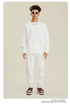 Model in white sweatsuit with white sunglasses, silver chain necklace and Nike high-tops