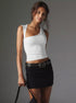 White one-shoulder top with black belt and accessories