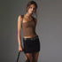 Brown one-shoulder top with black mini skirt and studded belt