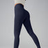 Model wearing navy blue high-waisted athletic leggings and cream top, side angle on gray background