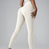 Model wearing ivory high-waisted leggings and matching top, side view against gray studio background