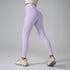 Model wearing lavender leggings and cream top with chunky white sneakers, rear view against gray background