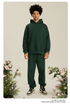 Man with curly hair wearing forest green hoodie and matching pants with brown and white sneakers