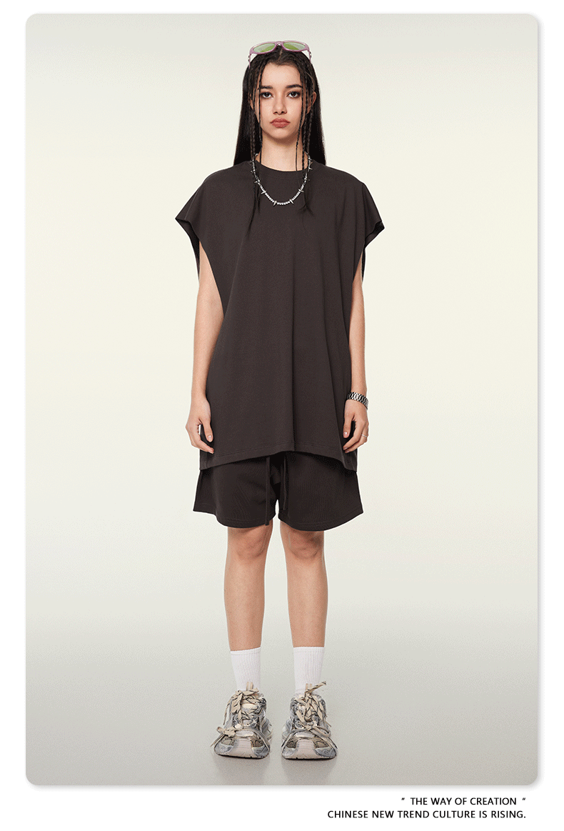 Female model in chocolate brown oversized tee and matching shorts set with chunky sneakers and sunglasses