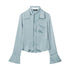 Light blue button-up blouse with wide cuffs and collar, laying flat