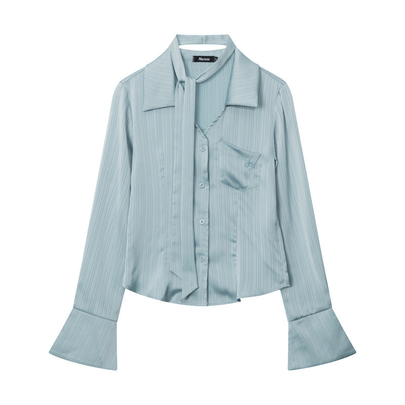 Light blue button-up blouse with wide cuffs and collar, laying flat