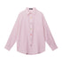 A flat-lay of a pink striped button-up shirt with a chest pocket and multicolored buttons, displayed against a white background