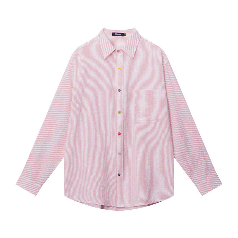 A flat-lay of a pink striped button-up shirt with a chest pocket and multicolored buttons, displayed against a white background