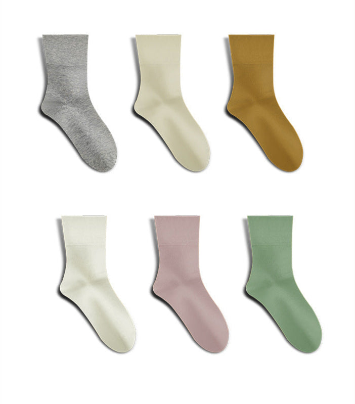 Six pairs of minimalist crew socks arranged in two rows, featuring gray, cream, camel, white, lilac, and sage green colors against white background