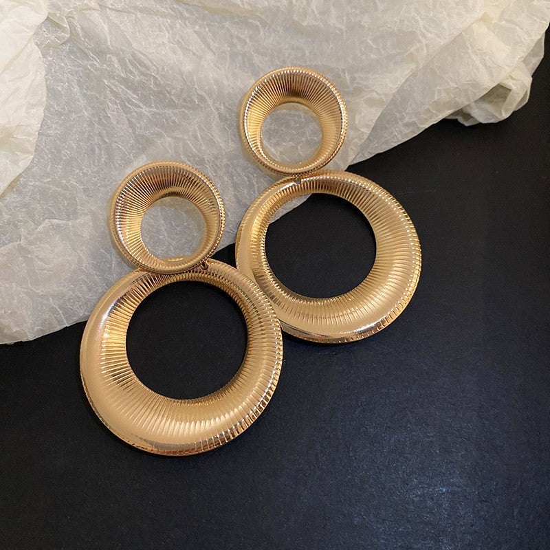 Oversized Gold Hoop Earrings – Statement gold hoop earrings with a ribbed texture, featuring double circular loops