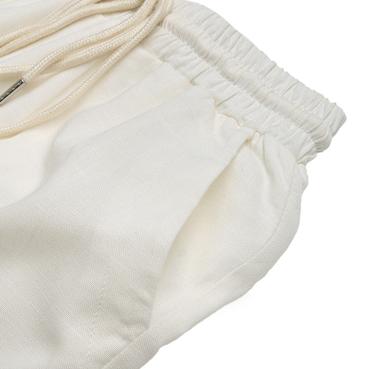Close-up of side pocket detail on white linen pants, highlighting soft breathable fabric.