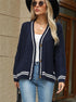 Cream cardigan with red stripes and star details, layered over white top for trendy look