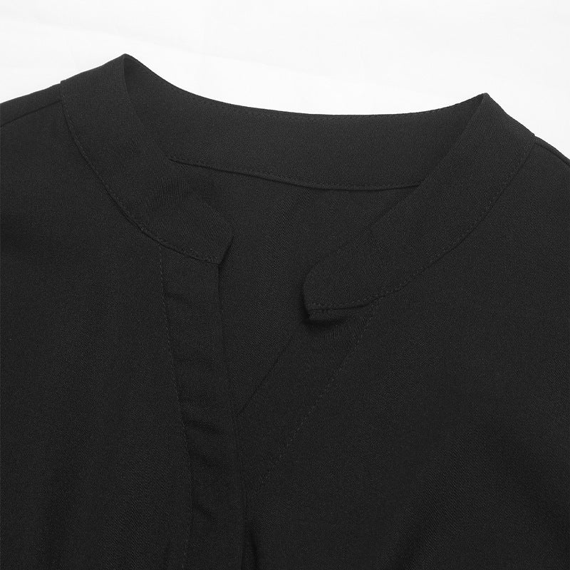 Detailed view of the neckline of a black jumpsuit, featuring a subtle V-cut design.