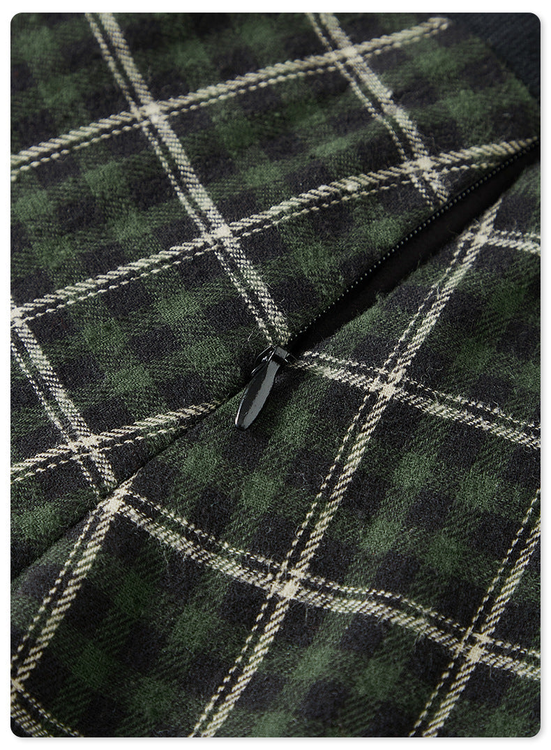 Close-up of zipper detail on green plaid fabric against dark background