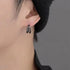 Black double-band earring modeled on ear with black beanie