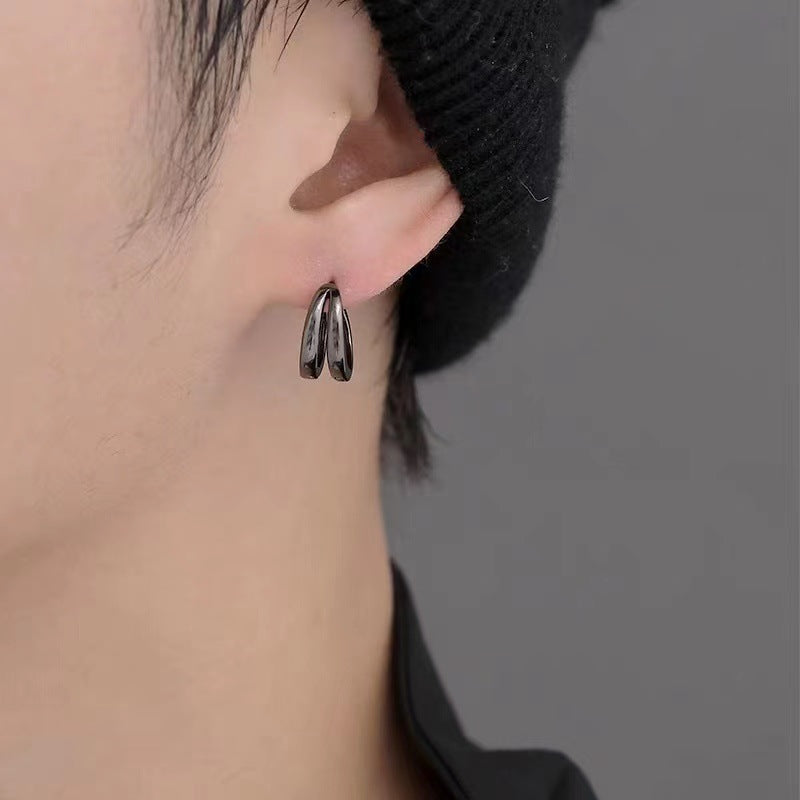 Black double-band earring modeled on ear with black beanie