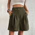 Model wearing army Green pleated shorts with dual button closure and side pockets, paired with white crop top