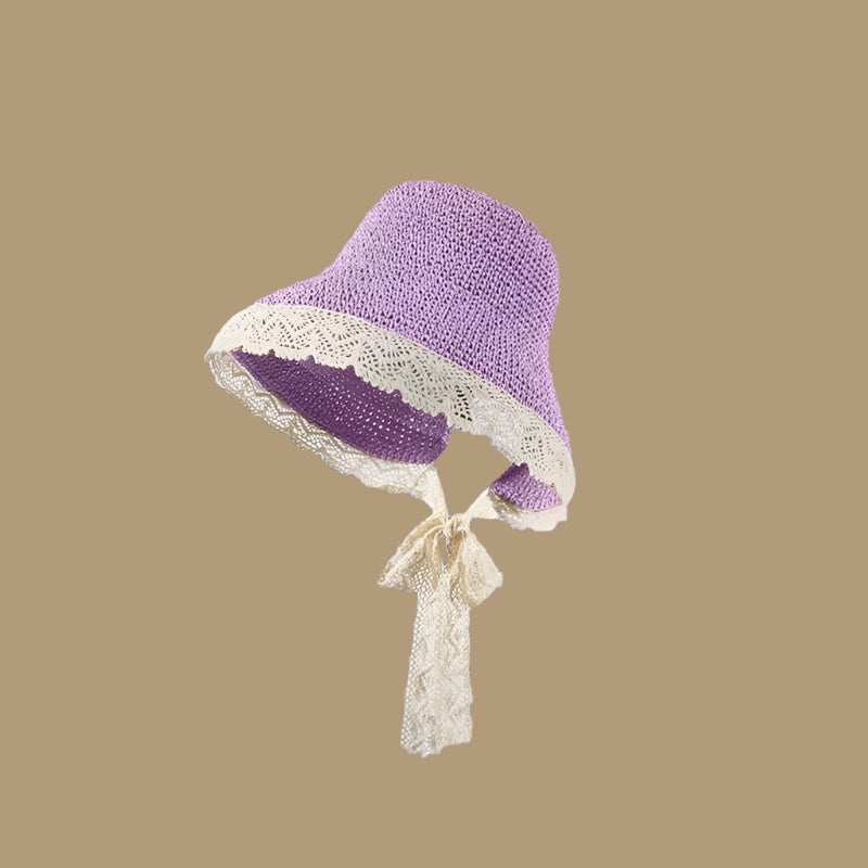Purple woven straw hat with lace trim and a tie, displayed on a solid brown background.