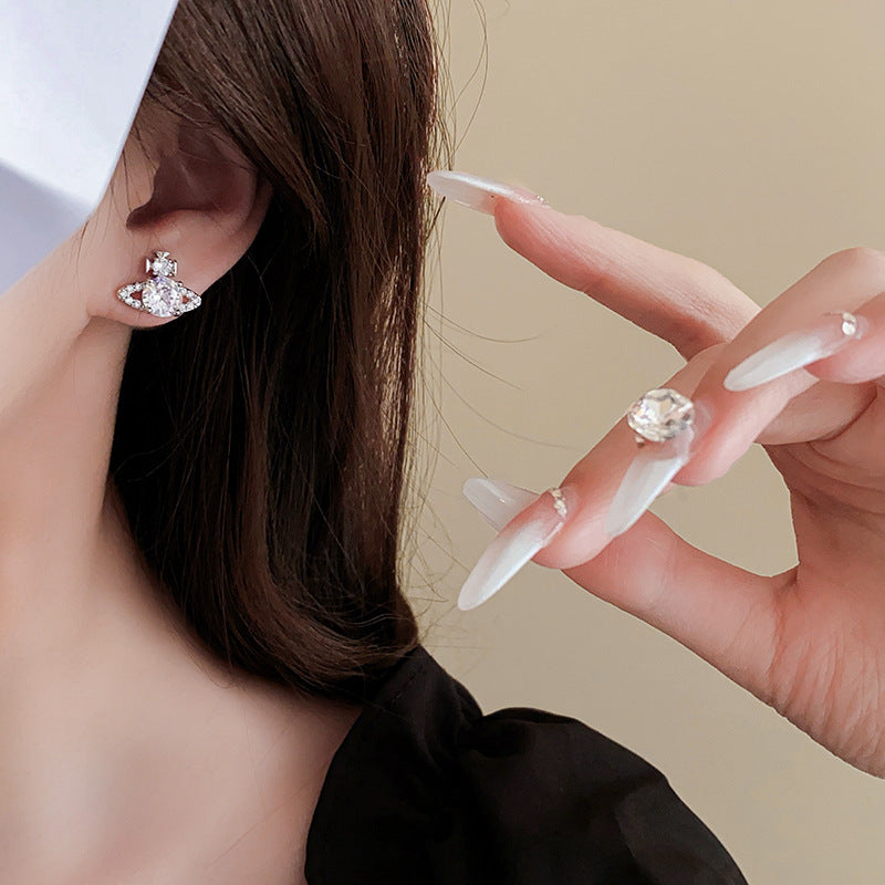 Close-up of designer celestial earring with long white nail