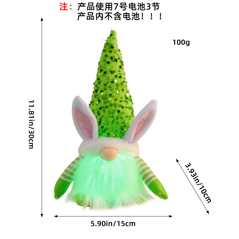 Green LED bunny gnome plush toy with striped arms and sequined hat, glowing and measured for reference.
