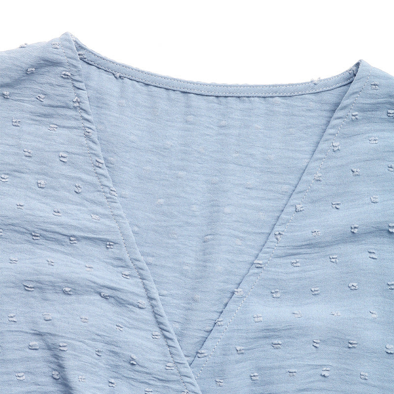 Close-up of the V-neckline of a baby blue babydoll dress, highlighting the fabric texture.
