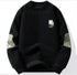 Black ribbed sweater with olive elbow patches and U logo patch