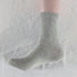 Single light gray cotton crew sock displayed against neutral background, emphasizing neutral color palette
