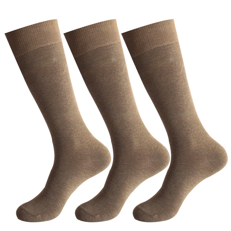 Three pairs of light brown dress socks with ribbed cuffs displayed against white background