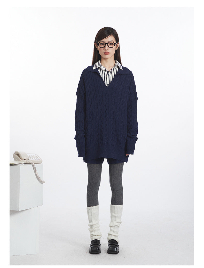 Full front view of navy cable knit set: V-neck sweater layered over striped shirt, coordinating shorts worn over grey tights.
