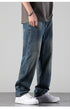 A person wearing relaxed fit vintage wash jeans with gray oversized t-shirt and metal chain bracelet, standing in white Nike Air Force 1 sneakers