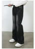 Close-up of model threading black leather belt through black wide-leg jeans with diagonal seam detail and white sneakers