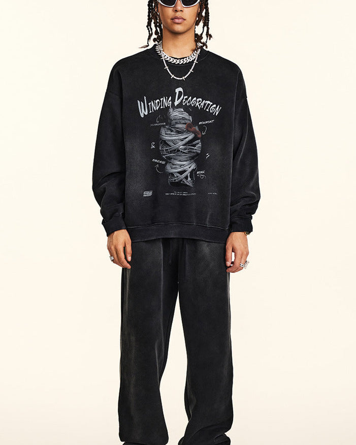 Full-length shot of model in matching black sweatshirt and wide-leg sweatpants, Winding Decoration graphic, white sunglasses, silver jewelry, animal print sneakers