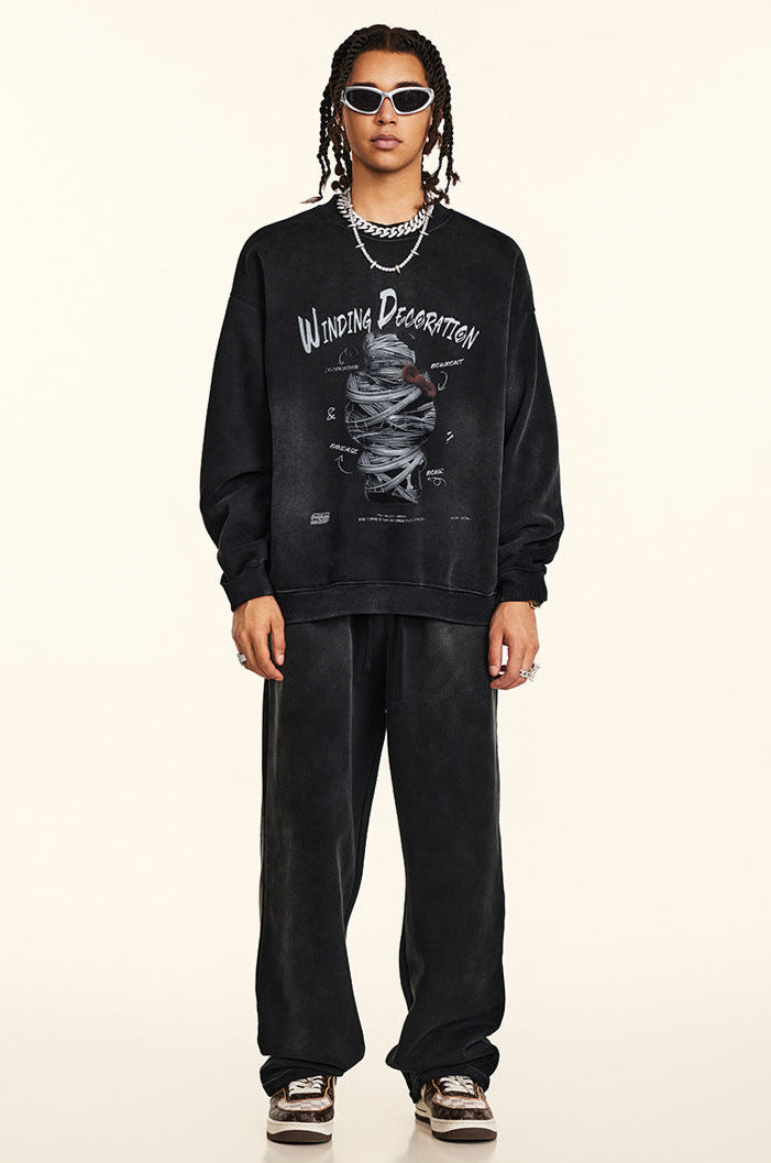 Full-length shot of model in matching black sweatshirt and wide-leg sweatpants, Winding Decoration graphic, white sunglasses, silver jewelry, animal print sneakers