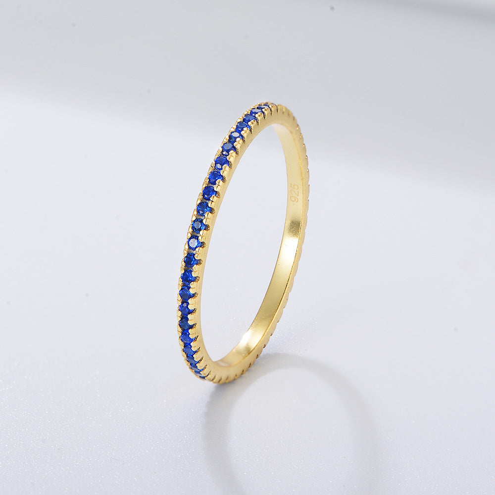 Blue sapphire eternity band in gold setting featuring deep royal blue stones in delicate prong design