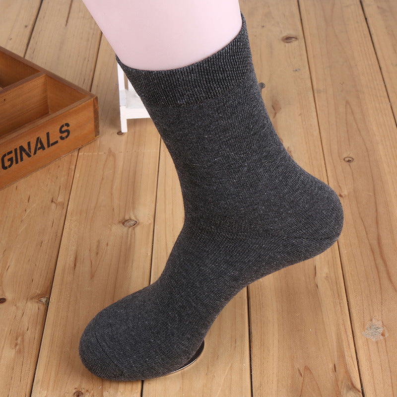 Dark gray ribbed cotton crew sock displayed on a white mannequin leg against wooden background